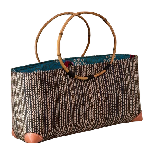 Textured handbag with bamboo handles on a white background